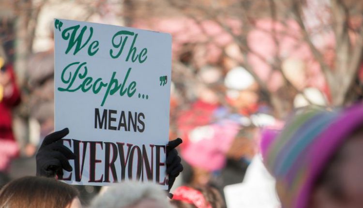 Cropped hands holding placard with text during protest in city